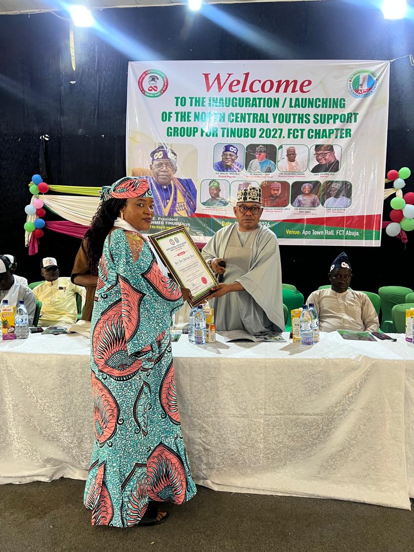 Anna Philemon Dara receiving a framed certificate at a youth support group inauguration in Abuja.