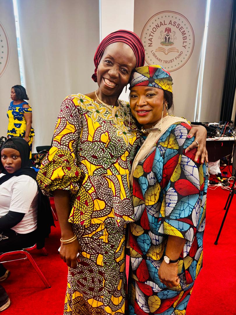 Anna Philemon Dara embracing a fellow participant after proceedings at the National Assembly.